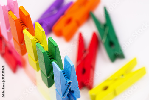 Set of colored clothespins on a white blurred background.
