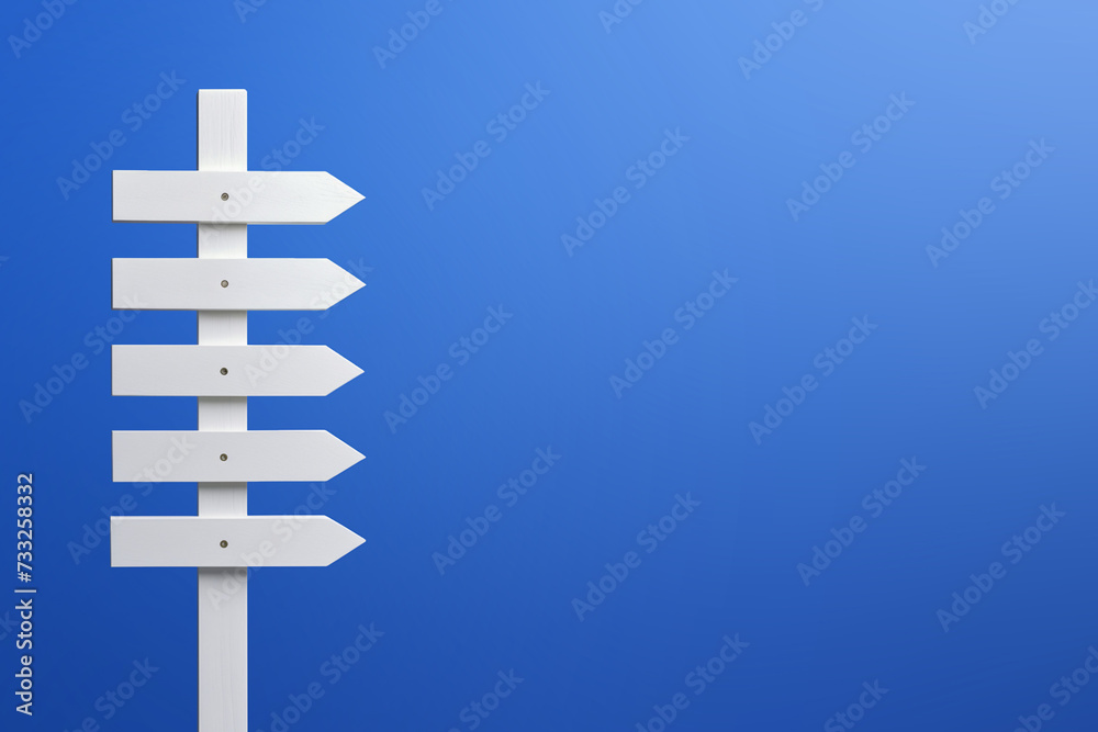 Wooden signpost on a blue background. Copy space. Wooden signpost on a blue background. Copy space.