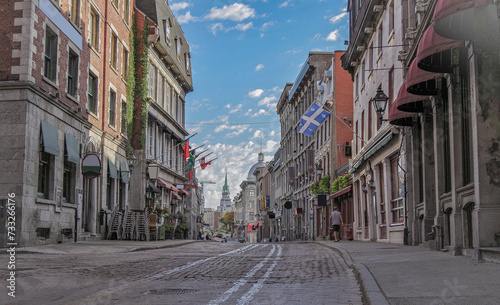 Fototapeta Naklejka Na Ścianę i Meble -  Pedestrian zone with shops, restaurants, city hall and historic architecture in downtown Montréal, Canada around Centre ville with landscaping and flower beds or floral arrangements in shopping area