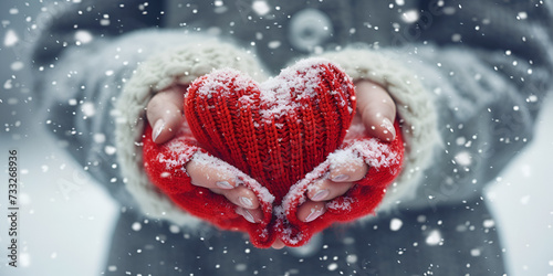 Female hands in knitted mittens with knitted heart on a snowy winter day Generative Ai 