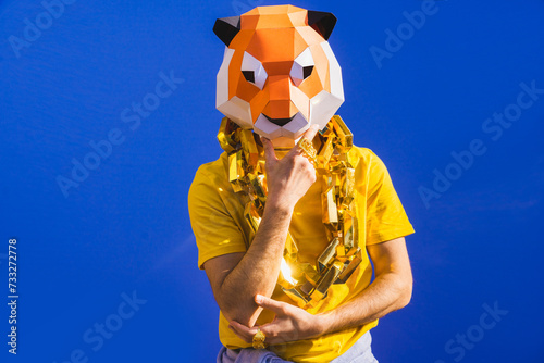 Cool man wearing colorful stylish suit with 3d origami animal funny mask on isolated colored background