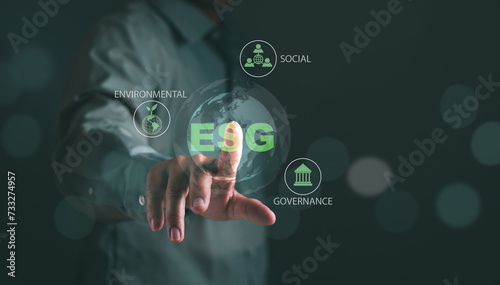 ESG Environmental, social and governance concept, sustainable organizational development ,Businessman's hand touches green ESG icon to plan investment with environmentally friendly businesses