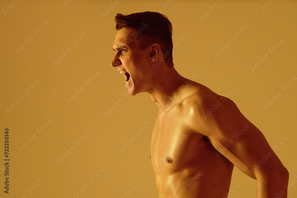 Fototapeta premium Athletic man with fit muscular body training in studio