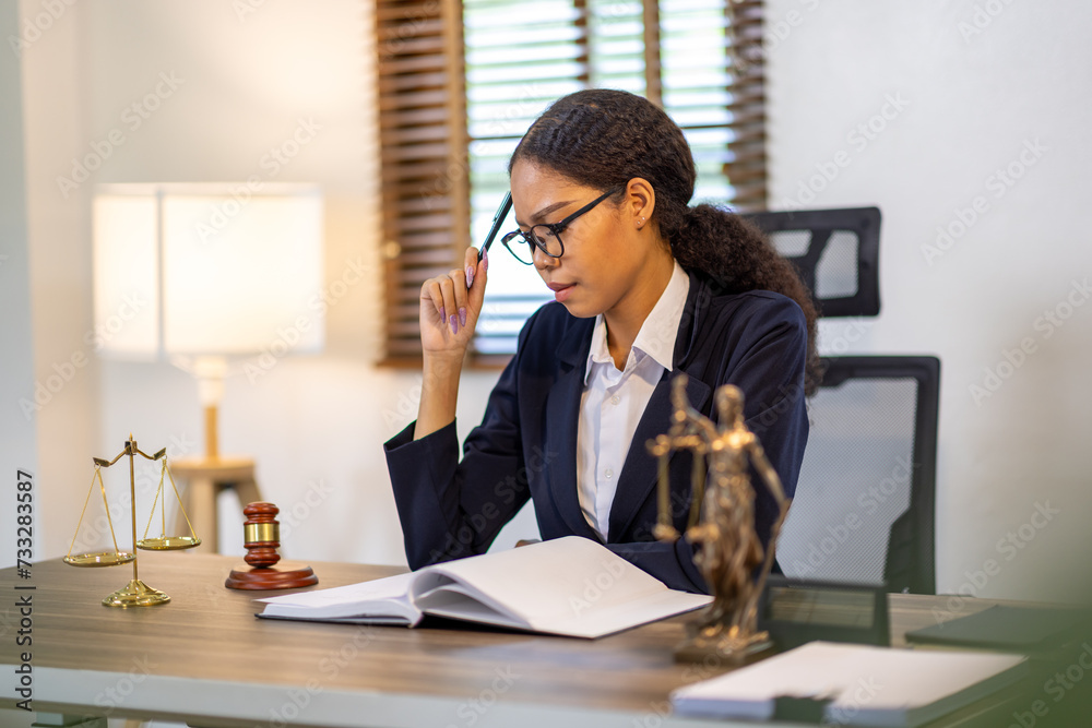 Portrait of young female Lawyer or attorney working in the office, analyzing data, reading contract documents work with law books hammer of justice Consulting lawyer concept. Portrait of young female Lawyer or attorney working in the office, analyzing data, reading contract documents work with law books hammer of justice Consulting lawyer concept.