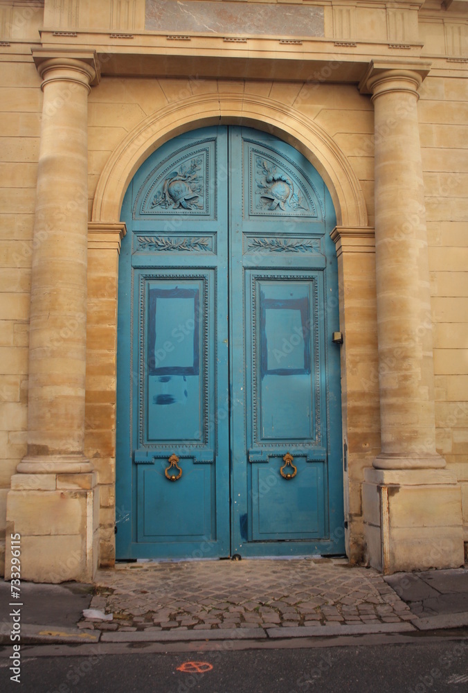 Old fashioned front door entrance, white facade and blue door, Paris, France