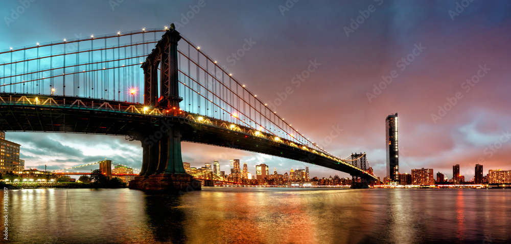 Fototapeta premium Panoramic view of Manhattan Bridge at night in New York. USA