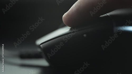 Clicking black computer mouse on a work desk. Close up. 