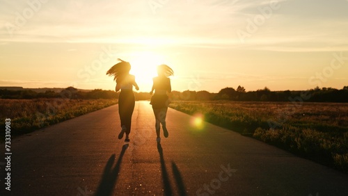 two friends running sunset, team group girls running sunset, silhouette athletic girls, teamwork young active sport athlete, sprint endurance exercise, stretching body, attractive asian woman, healthy photo
