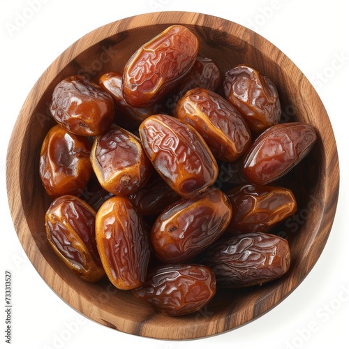 dried dates in a wooden plate top view isolated on white background