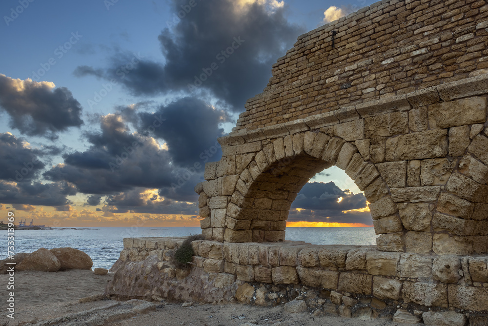 Aqueduct built by the Romans against the sky at sunset in Caesarea Israel