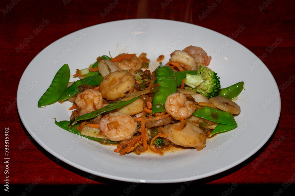 Stir fried shrimp and vegetables on a white plate