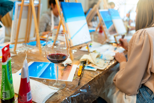 Sip and Paint Event. Painting with a glass of wine in hand photo