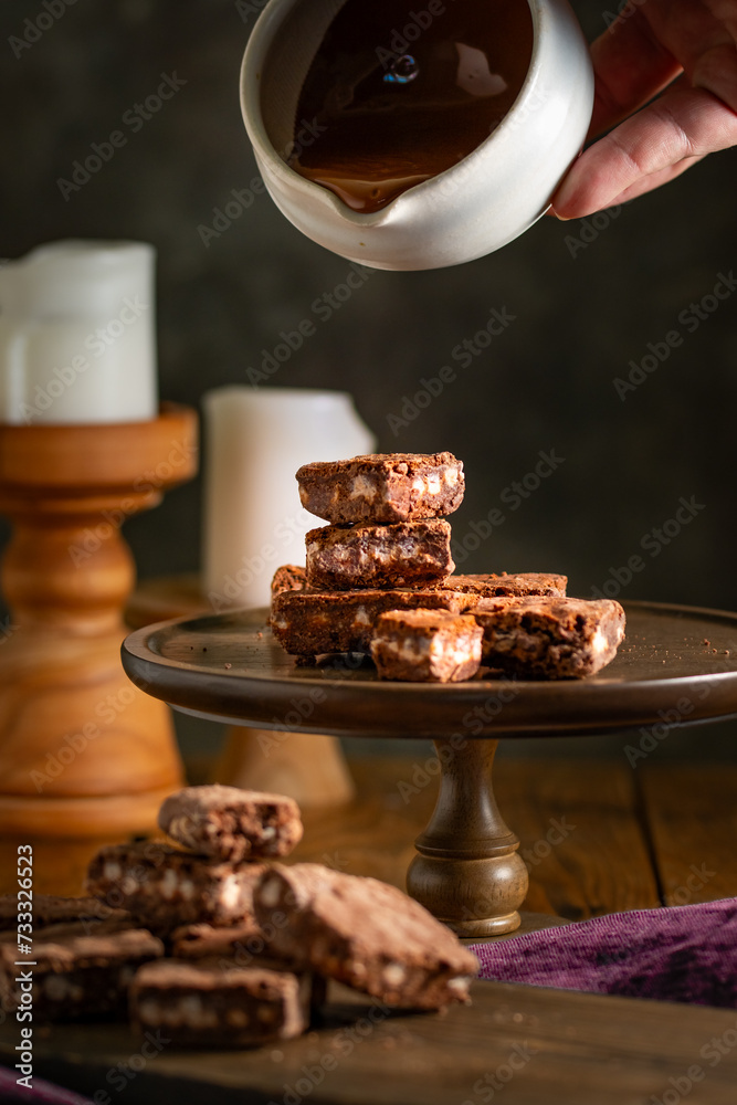 Pouring melted chocolate over brownies.
Bakery, confectionery concept.