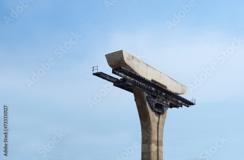 structure of bridge under construction with blue sky background.