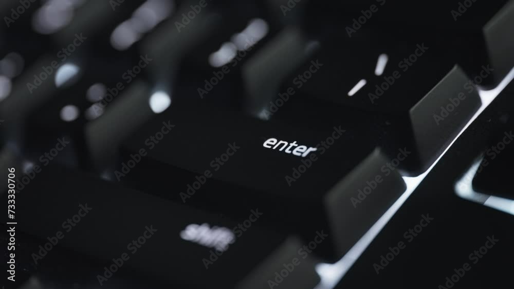 Pressing the enter button on black computer keyboard. Close up. 