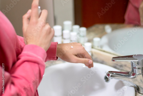 Cropped image of woman applying cream to her hand