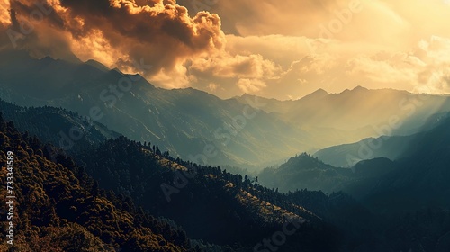 The image captures a breathtaking mountainous landscape during sunset. The sun is visible through the clouds, casting a warm golden light that creates a dramatic atmosphere. Sunbeams break through the