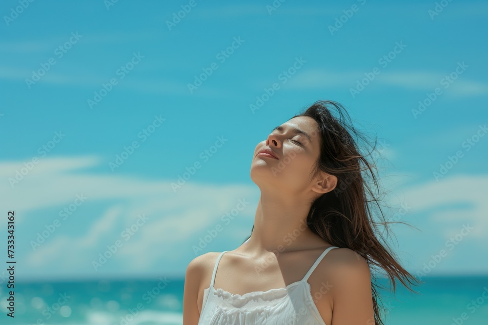 A young woman breathes the pure sea air on vacation.