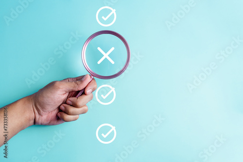 approval, approved, check, checkmark, choice, choose, confirm, correct, cross, decision. hold a magnifying for right or wrong marks on blue background color, the concept of choice without people.