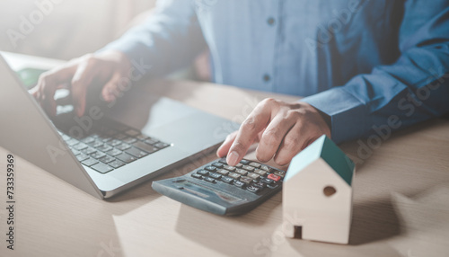 home  loan  money  economy  finance  financial  house  investment  banking  budget. pressing calculators  hand plans home refinance. house model  buy or rent  calculators on desk. saving for property.