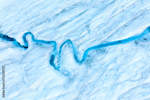 An aerial view of an iceberg and river. Winter landscape from a drone. View of the moraines. Landscape from the air. River on a moraine.