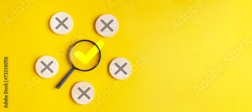 approval, approved, check, checkmark, choice, choose, confirm, correct, cross, decision. holding magnifying glass looking for right or wrong marks on wooden dice, the concept of choice without people. photo