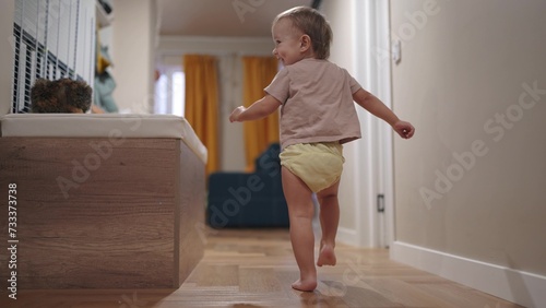 baby run along the corridor indoors. happy family kid dream concept. baby first steps playing run around at home. son, child, active, runs, takes first steps, plays lifestyle indoors