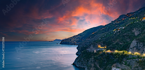 Amalfi Coast, Italy. View over Praiano on the Amalfi Coast at sunset. Street and house lights at dusk. In the distance the island of Capri on the horizon. Amalfi Coast road. Banner header image.. © Alessandro