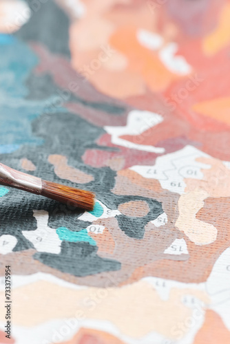 Painting by numbers, close up of brush tip on canvas, selective focus.