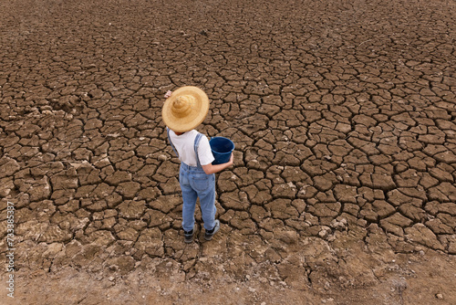 People in middle of dry field, weather problems, drought, bucket