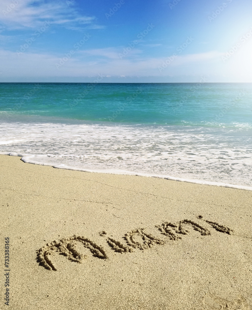 Miami text spelled in the sand in South Beach with sunny sky and clear blue ocean water Miami text spelled in the sand in South Beach with sunny sky and clear blue ocean water
