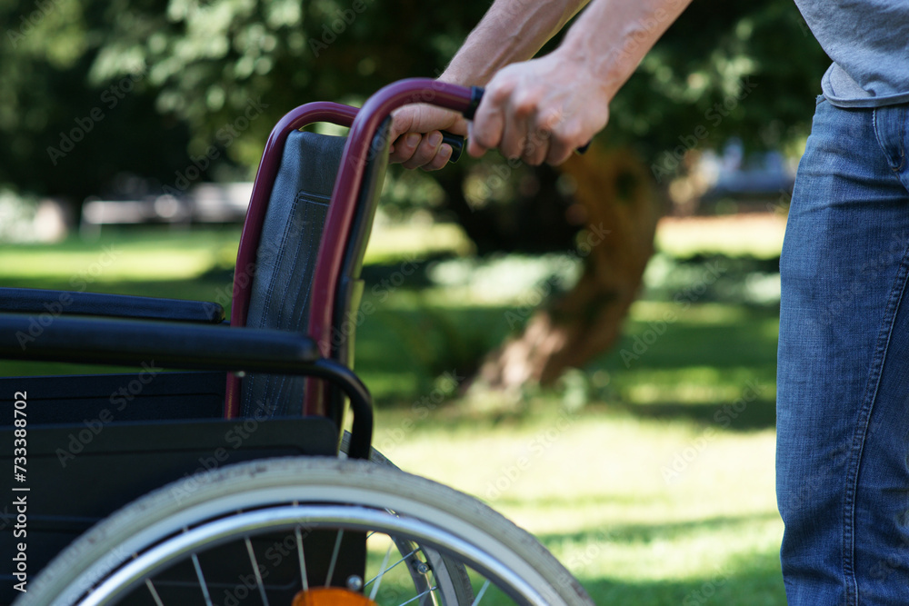 First steps on his own - man pushes empty wheel chair First steps on his own - man pushes empty wheel chair