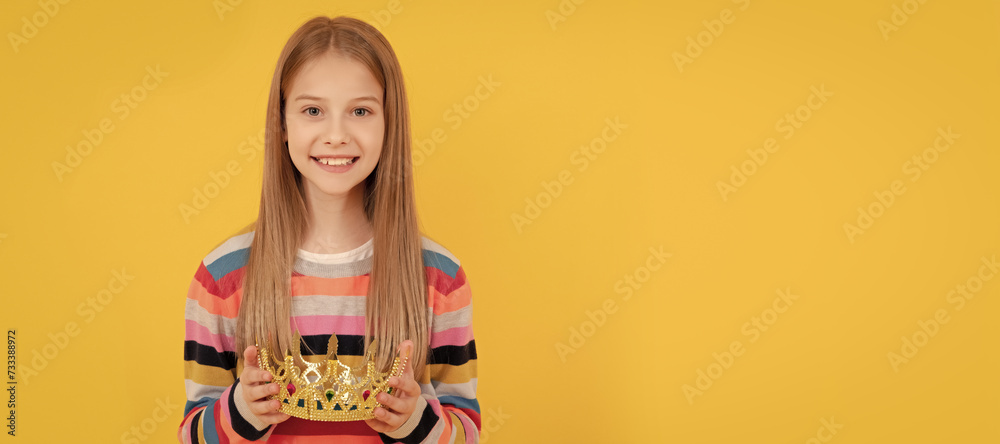 positive teen child hold queen crown on yellow background. Child queen princess in crown horizontal poster design. Banner header, copy space. positive teen child hold queen crown on yellow background. Child queen princess in crown horizontal poster design. Banner header, copy space.