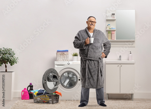 Full length portrait of a mature man wearing a robe and holding a cup photo