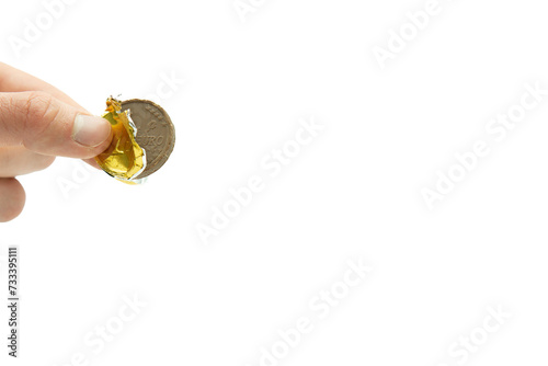 Male hand holding chocolate coin, stack of coins in the background isolated on white background, copy space