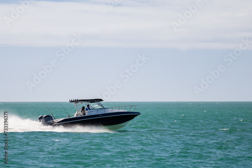 Saltwater fishing boat on a sunny summer day. People on recreational power boat cruising the Gulf of Mexico, Florida.