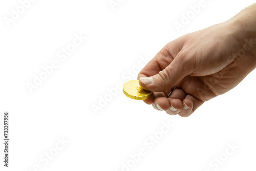 Male hand holding chocolate coin, stack of coins in the background isolated on white background, copy space
