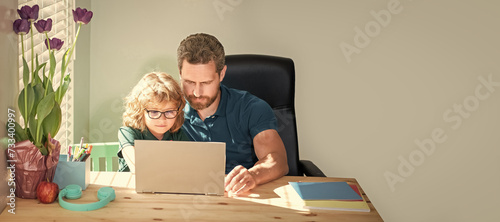 Banner of home school of father and son with laptop at home, concentrated father and son in glasses use computer. family blog. nerd boy do homework photo