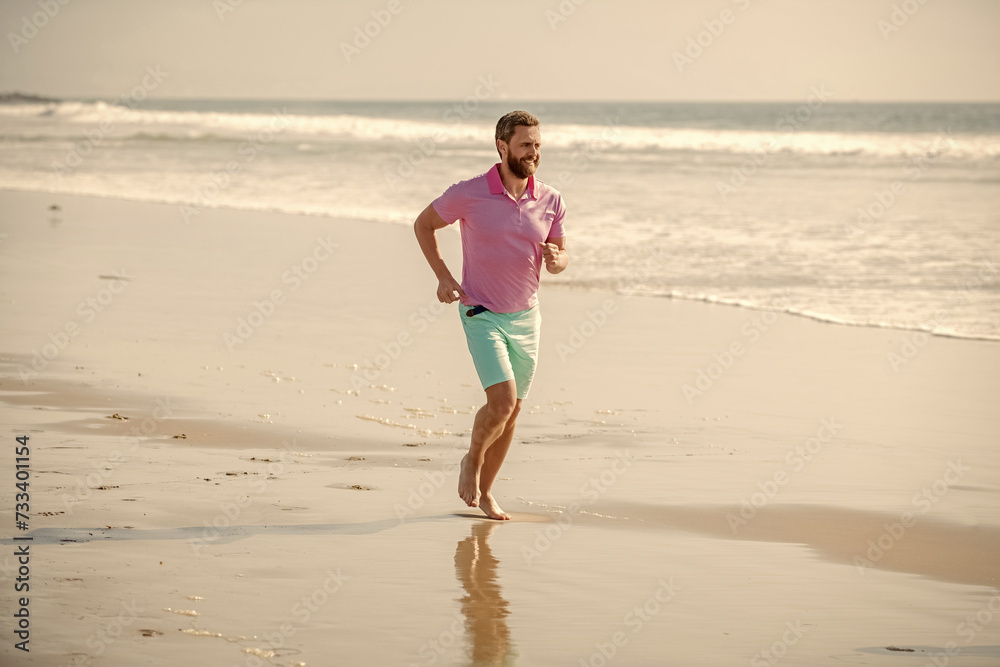 athletic man running on summer beach for training, summer