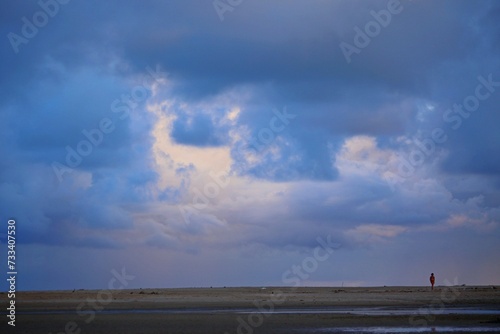 Blue sunrise on Japaratinga beach, Alagoas state, Brazil. First day light on the sea and sky. Clouds and sun light reflections.