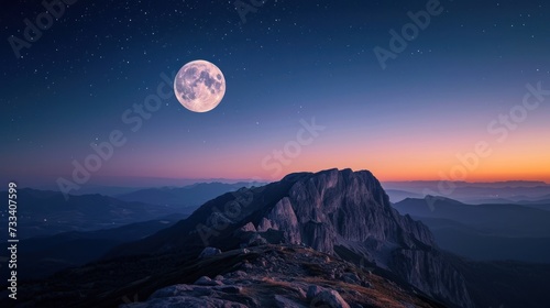  a full moon rising over a mountain with a view of the top of the mountain in the foreground and a few stars in the sky above the mountain range.