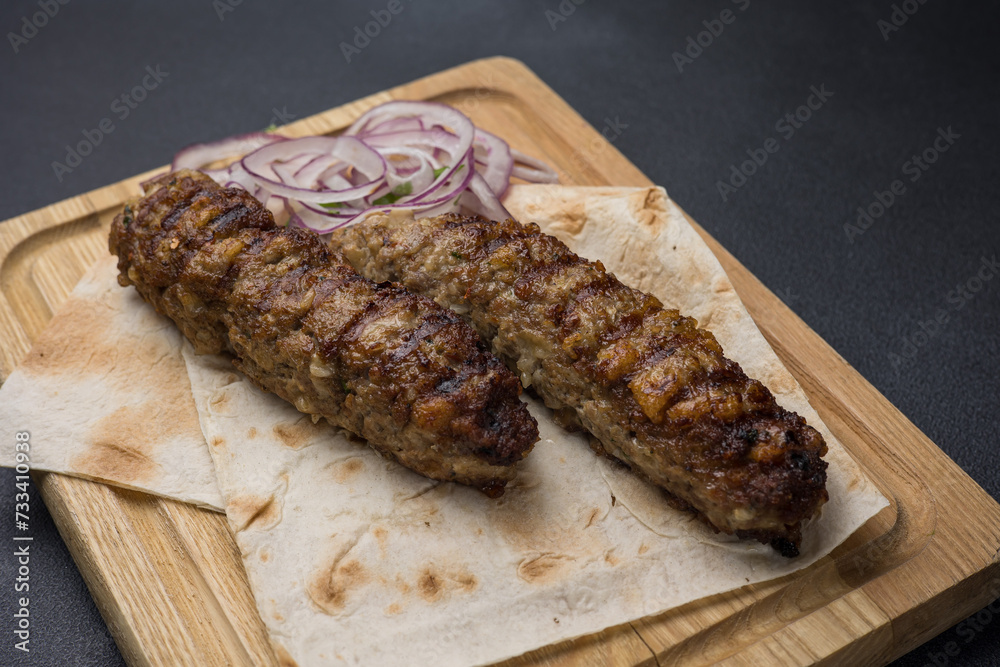 Delicious Lyulya kebab on a wooden board. Close-up Delicious Lyulya kebab on a wooden board. Close-up