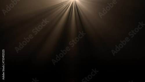 Studio shot of projector haze isolated on black background. Warm light rays shining from above with smoke mist in darkness. photo