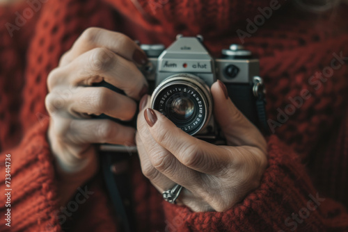 woman's hands are shown in close-up, holding a vintage camera