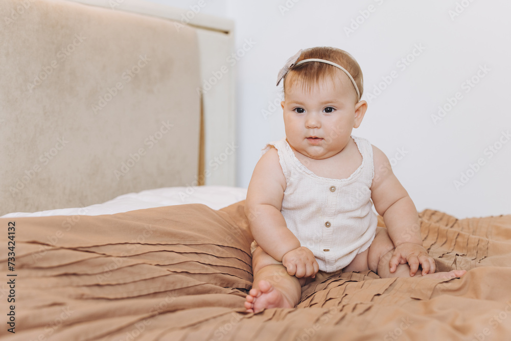 Portrait of a little baby girl smiling and crawling on the bed in the bedroom Portrait of a little baby girl smiling and crawling on the bed in the bedroom