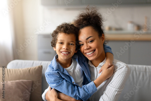 Joyful black mother and son sharing warm, loving embrace
