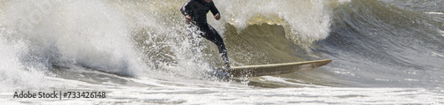 Surfer riding in front of a big wave at Giglo Beach