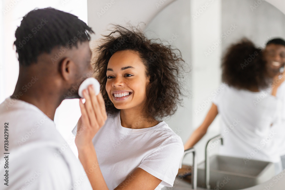 Happy African American couple engages in facial skincare in bathroom Happy African American couple engages in facial skincare in bathroom