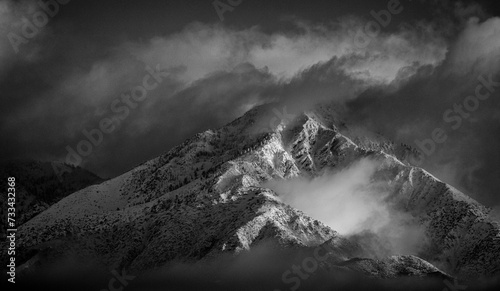 Black and White image of Mountains in Angeles National Forest covered in snow during a storm. The shot is looking west from the 15 freeway at the Limonite Ave park and ride in Mira Loma Ca