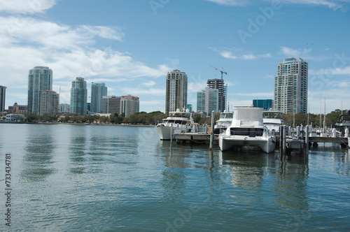 Cityscape of water with tall buildings on a sunny day with boats in the foreground. With a blue sky on a sunny day at the Vinoy  Basin waterfront in St. Petersburg, Florida. reflections in water.  © Del Harper